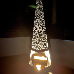 Decorative lamp with intricate cut-out design on a dark background